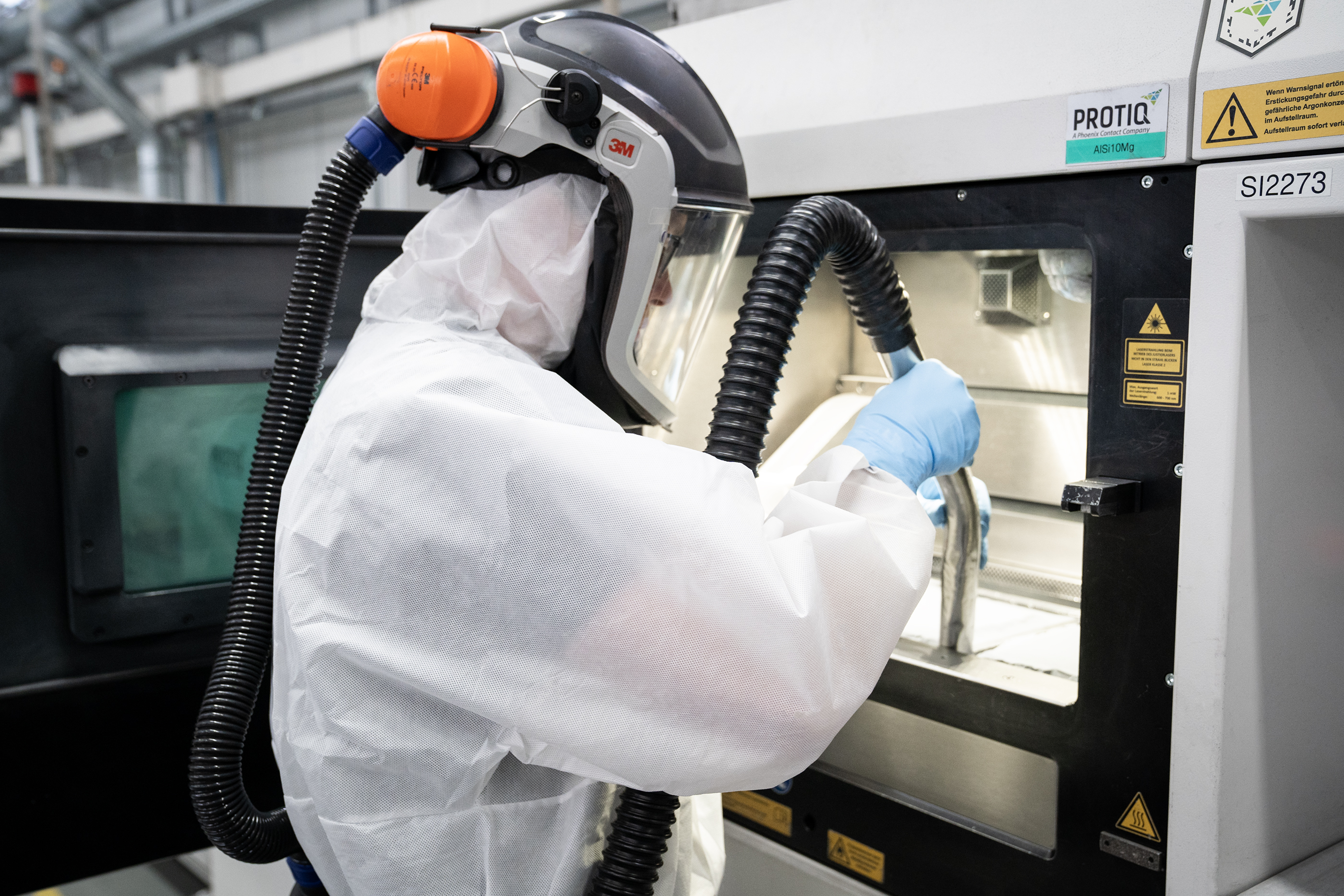 Employee unpacking a metal 3D printing build job